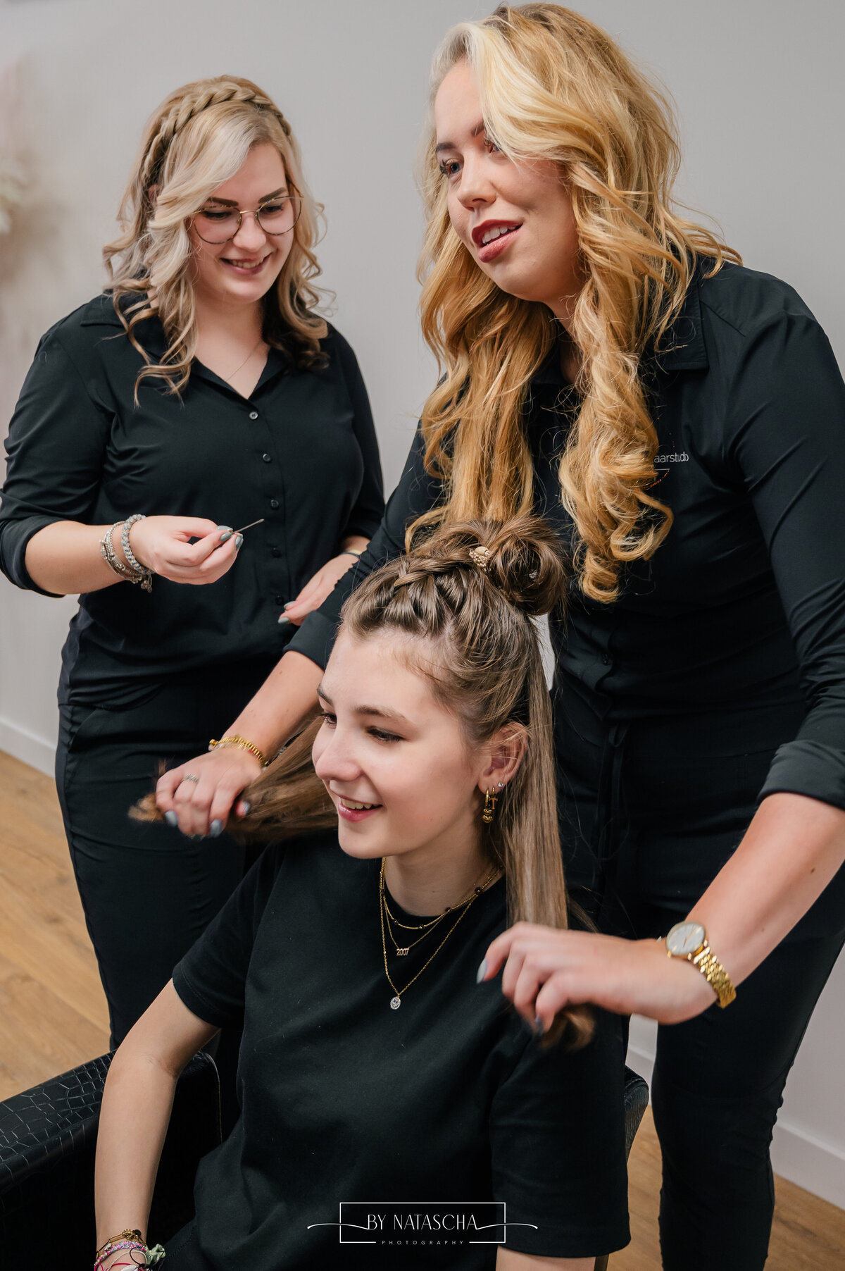 Haarstudio Heesch met de medewerkers en klant terwijl ze het haar vasthouden en. goedleggen voor de finishing touch