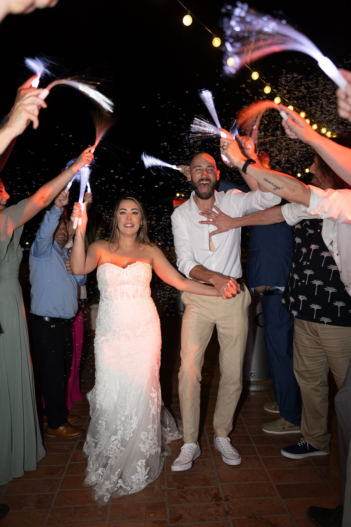 Bride and groom grand exit with bubbles and glow wands at Hilton Beachfront Resort Santa Barbara