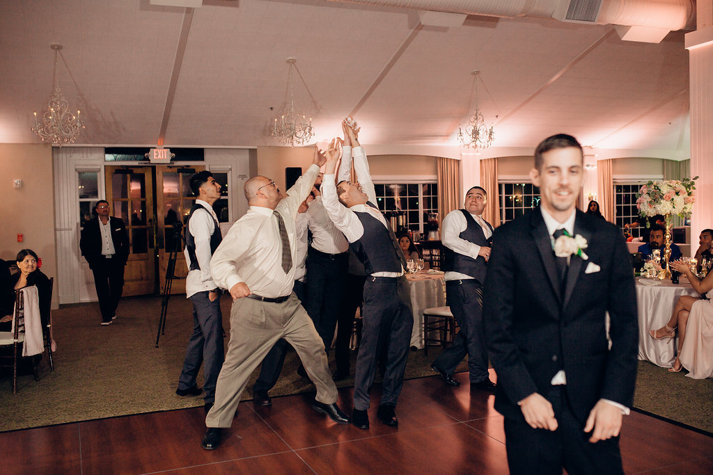 Wedding Photograph Of Men Raising Their Hands For The Wedding Garter Los Angeles