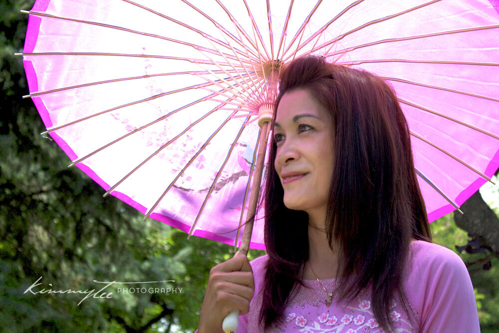 Beautiful Vietnamese women holding Asian umbrella parasol under the sun