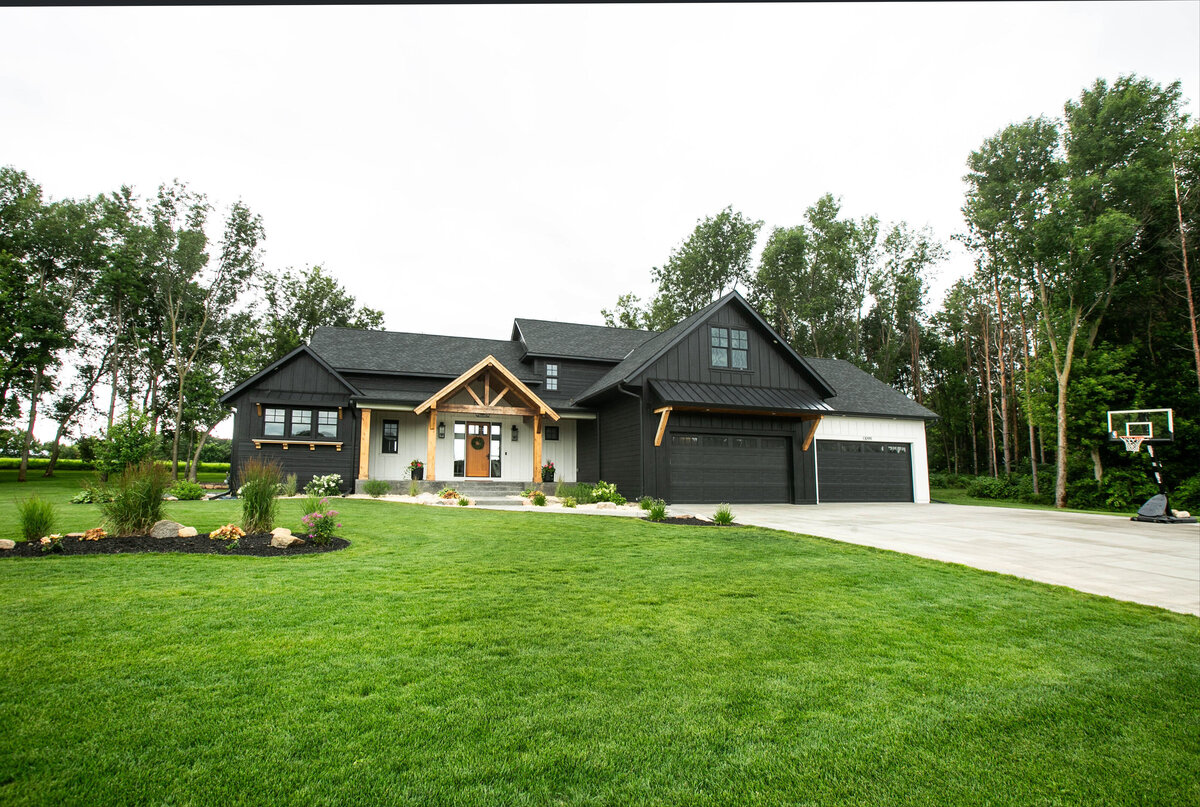 Exterior view of custom home in Otsego, Minnesota with modern wood details and front porch built by Cornerstone Custom Builds