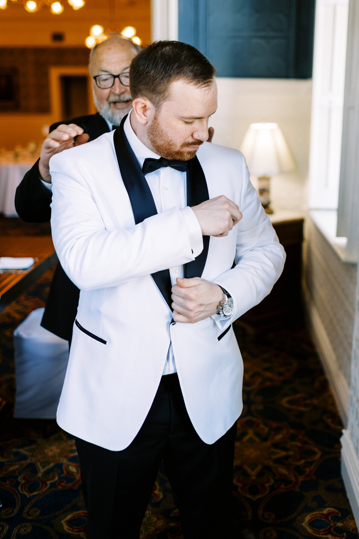 dada helping his son on his wedding day with his jacket