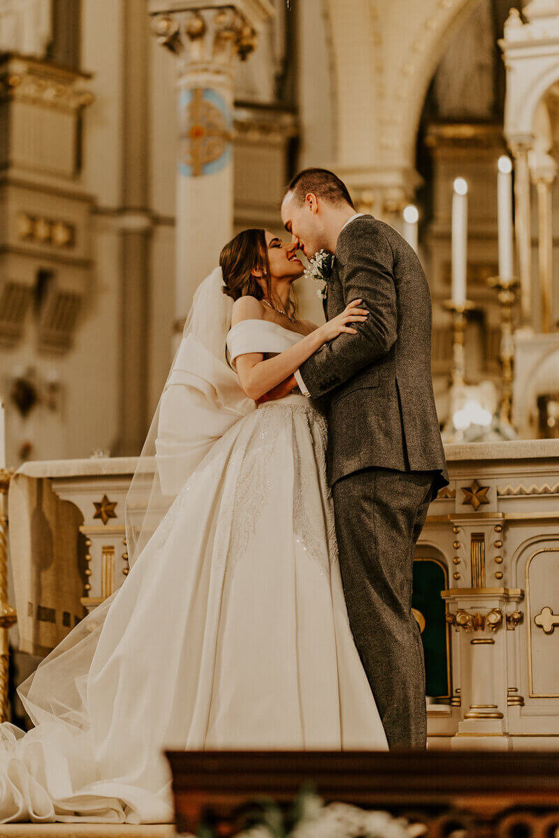 Mariés sur le point de s'embrasser sur l'autel à l'église à Montréal,  immortalisés par Laura termeau, photographe de mariage.