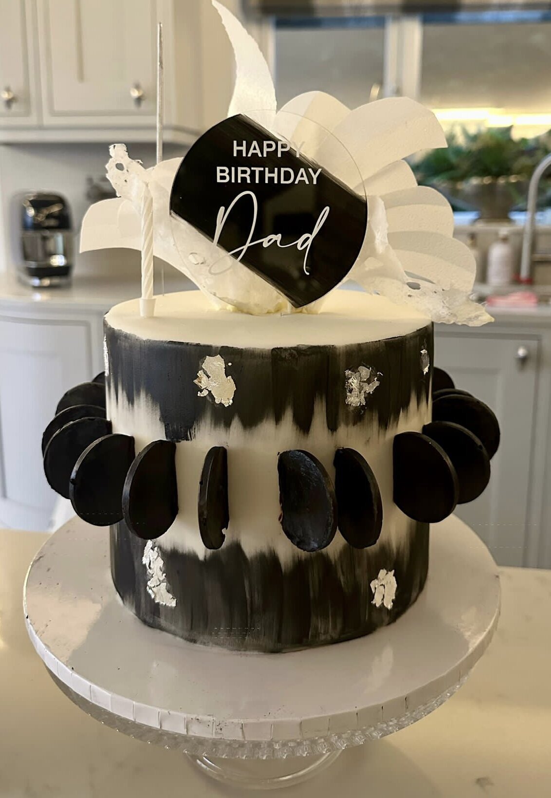 Egg free black and white birthday cake with handmade chocolate discs, wafer paper elements and edible silver.