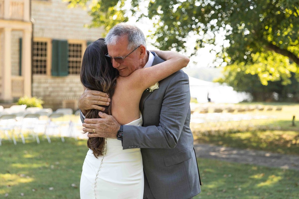 Bride hugging dad after first look on wedding day