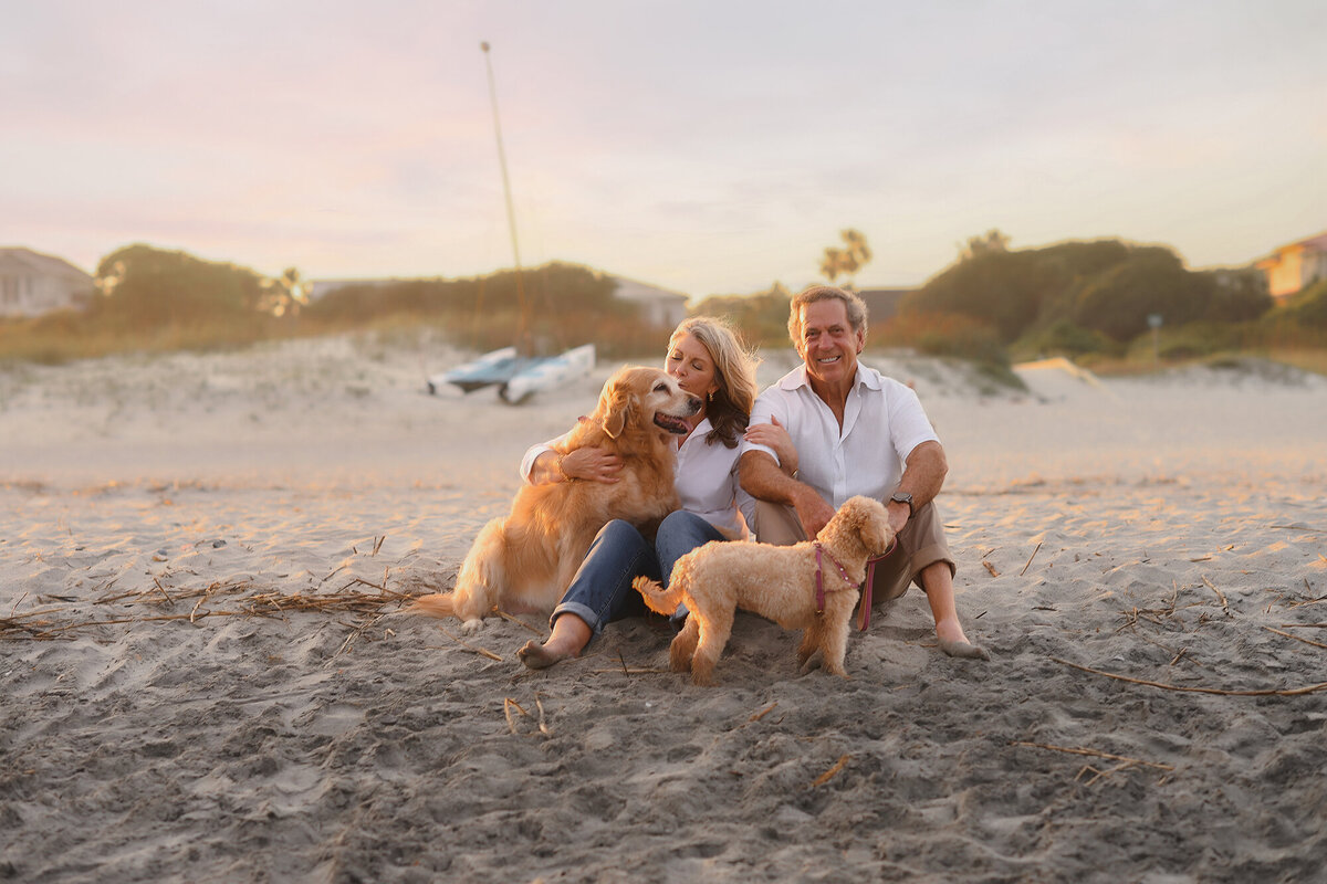 Couple sits together with their dogs during Family Pictures on Isle of Palms. 
