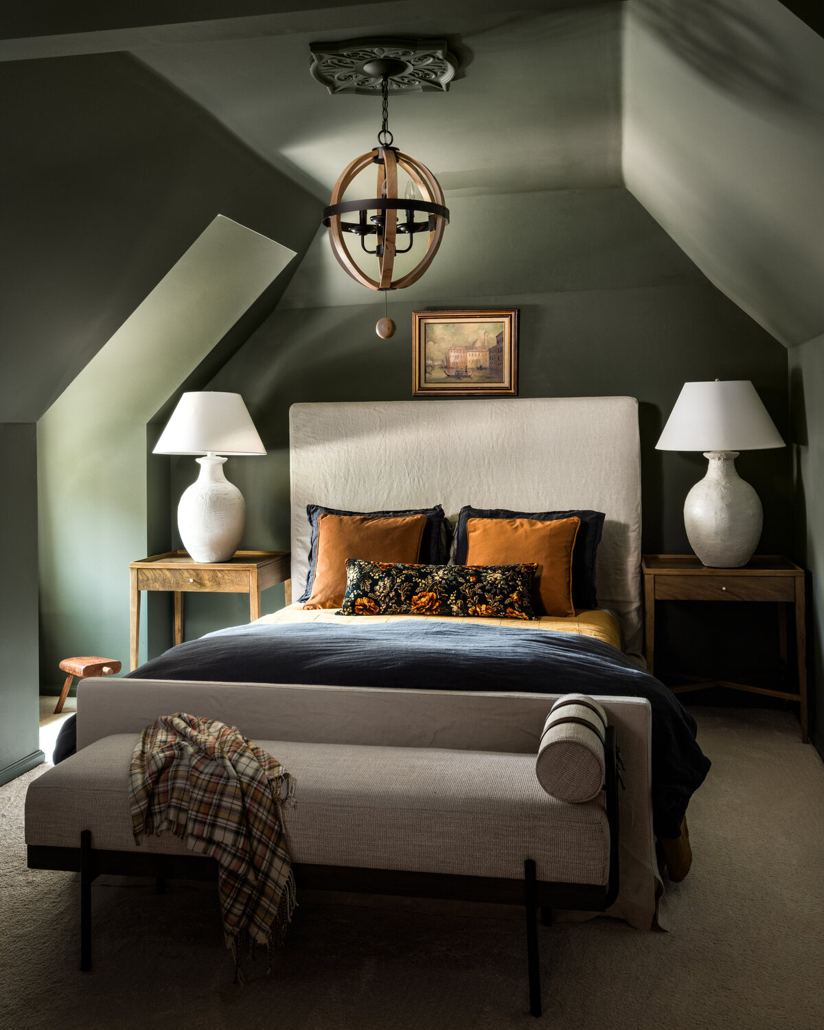 Unique attic bedroom in Concord, NC, with deep green walls, a cozy bed, and warm lighting.