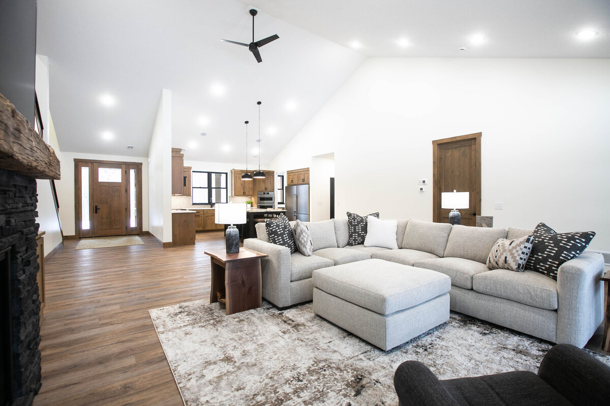 Cozy living room in Elk River custom home with fireplace, built-ins, and large windows