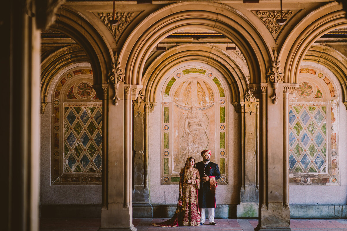 A pakistani muslim bride and groom look under the mural arch at bethesda terrace in central park