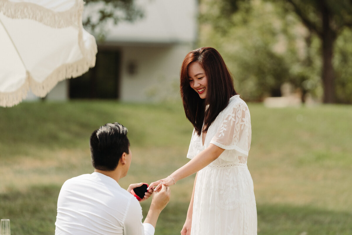 Unique proposal ideas man on one knee putting ring on woman's finger