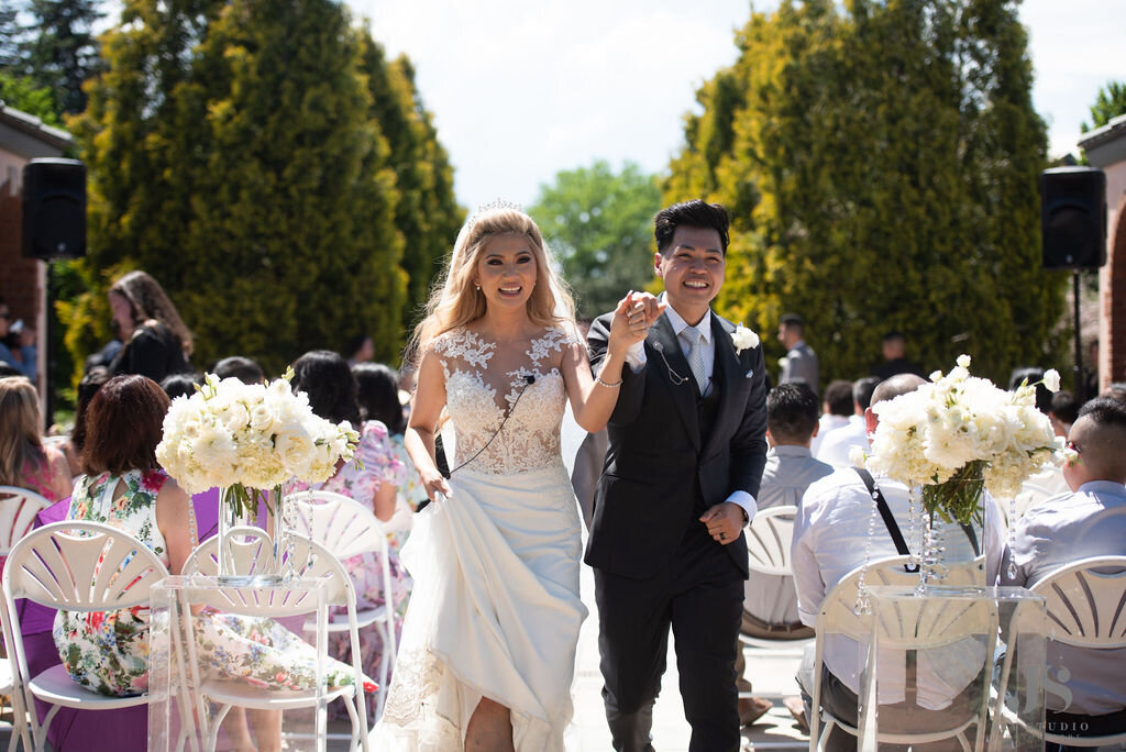 Bride and groom walk down the aisle at the Denver Botanic Gardens.