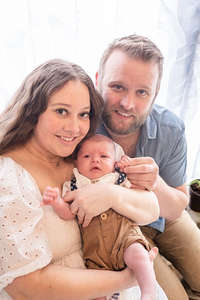 newborn boy with smiing parents