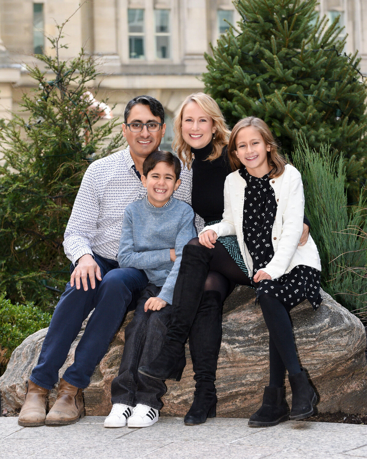 Urban city family portrait outdoors sitting on rocks