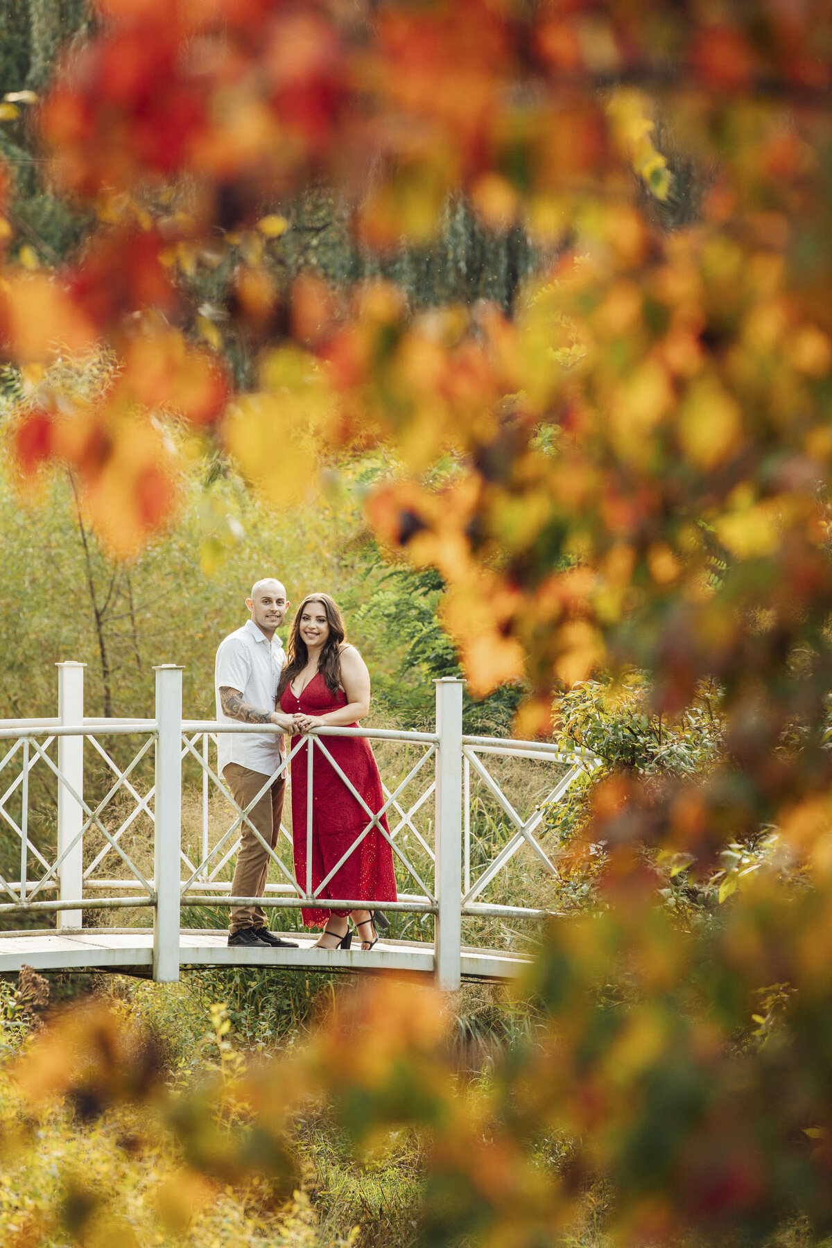 Couple on white bridge during fall engagement shoot at Sayen House and Gardens in Hamilton Township New Jersey