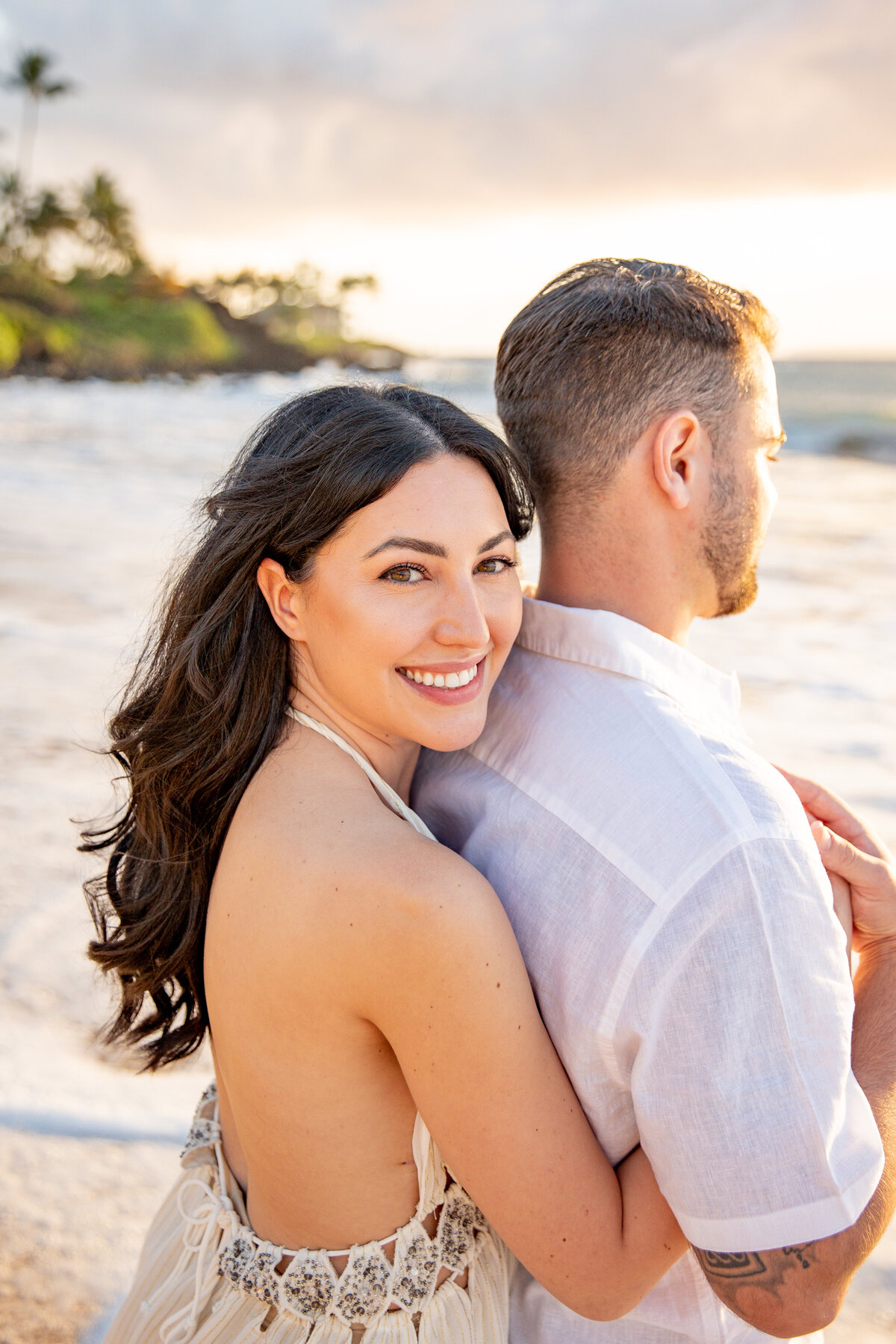 Maui Couples Photographer captures woman hugging man from behind and smiling