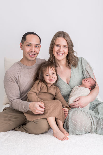 Family of four sitting down together with newborn baby at Portland newborn photo session