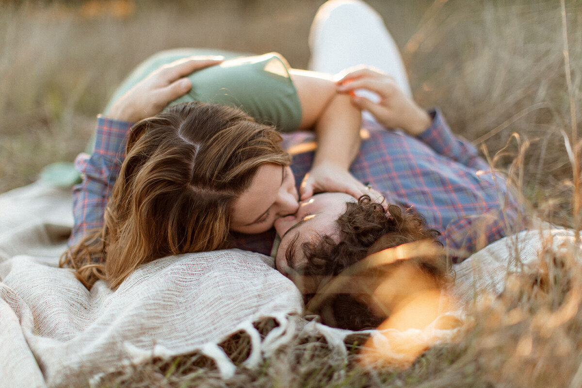 Intimate couple portrait lying together in field - Sara James San Antonio photographer specializes in romantic couples sessions and engagement photography in beautiful Texas outdoor settings