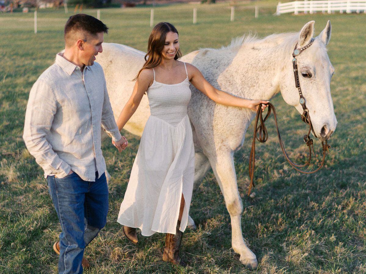 engaged-couple-laughing-with-horse
