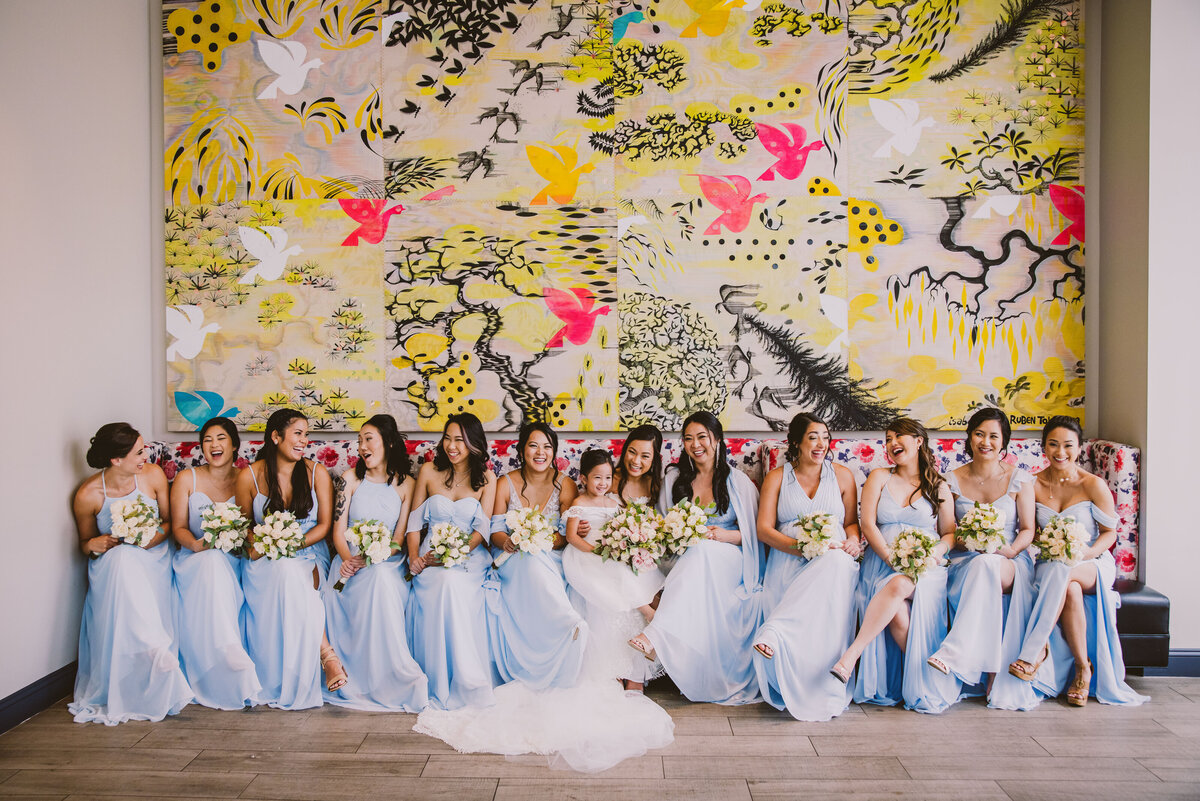 An asian vietnamese christian bride in white gown sitting with her bridal party wearing blue dresses at the MC hotel in Montclair, NJ