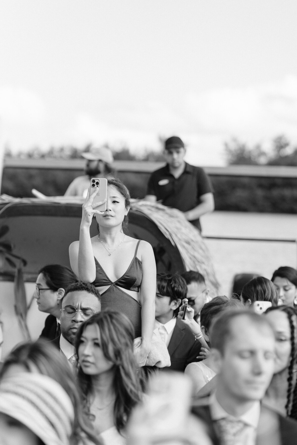 Wedding guests on Kualoa Ranch boat one guest standing holding iphone