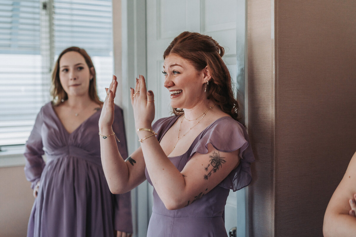 Bridesmaid reacts with joy and excitement during the getting ready moments at Lesner Inn in Virginia Beach, Virginia.
