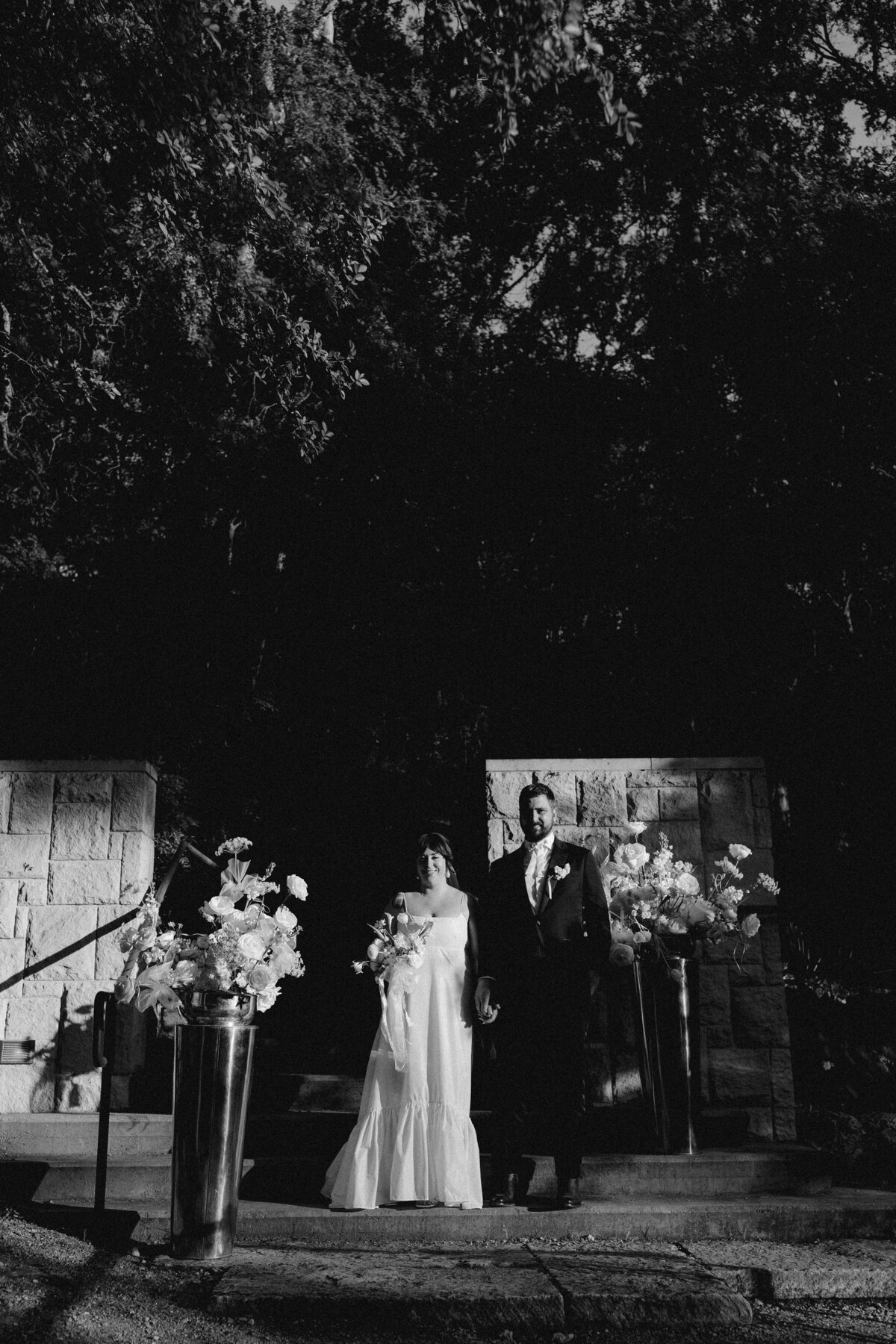 Bride and groom standing on ceremony site at Umlauf Sculpture Garden, Austin