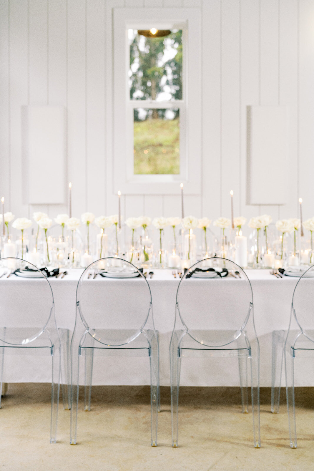 A table with candles, roses, and place settings at a styled wedding photography shoot.