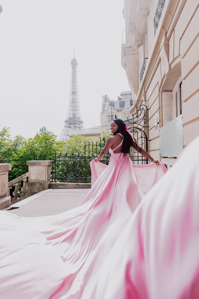 Dynamic Paris portrait capturing woman running in flowing blush pink gown through Parisian street towards Eiffel Tower