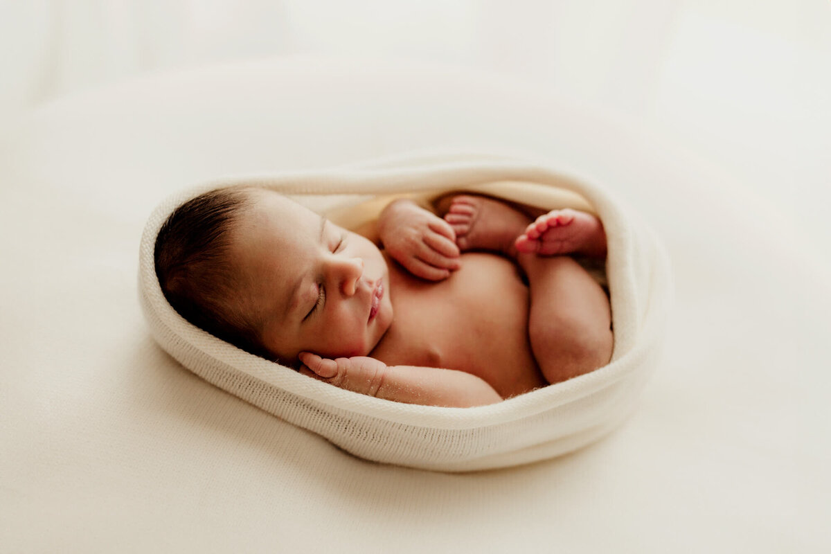 Womb pose of a baby boy sleeping, Edmond newborn session.