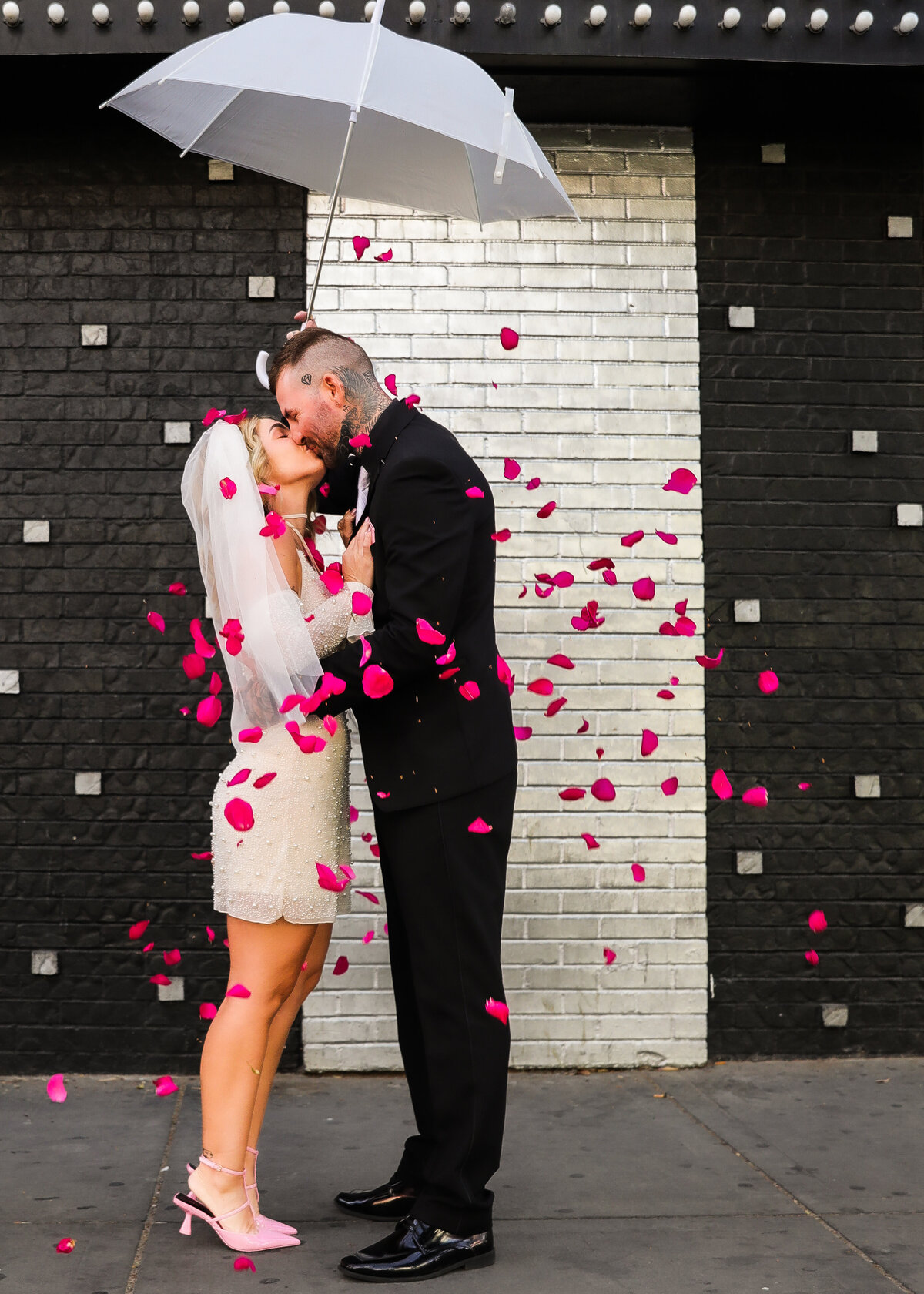 romantic wedding kiss with shower of rose petals