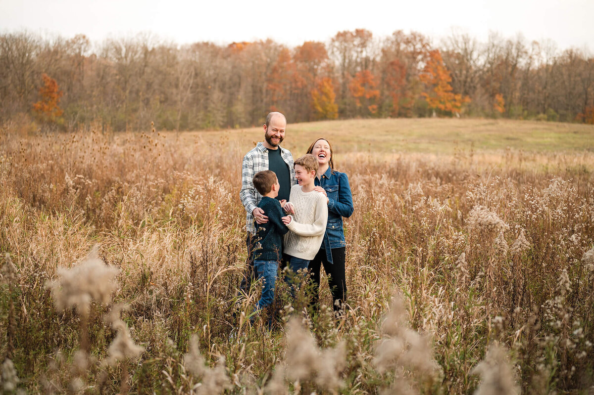 Family laughing in the middle of a field at lefurge woods nature preserve