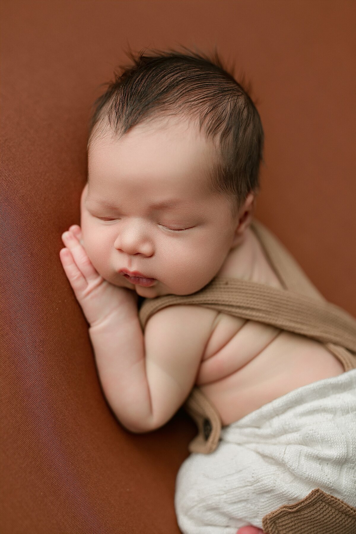 Harrisonburg Newborn photographer picture of newborn baby boy on orange backdrop