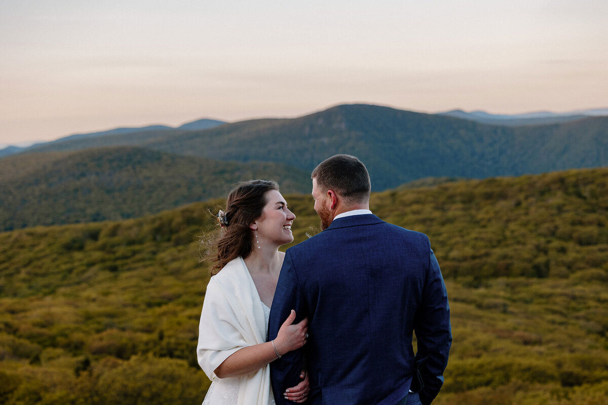 A bride looking at her groom at an overlook at Shenandoah National Park