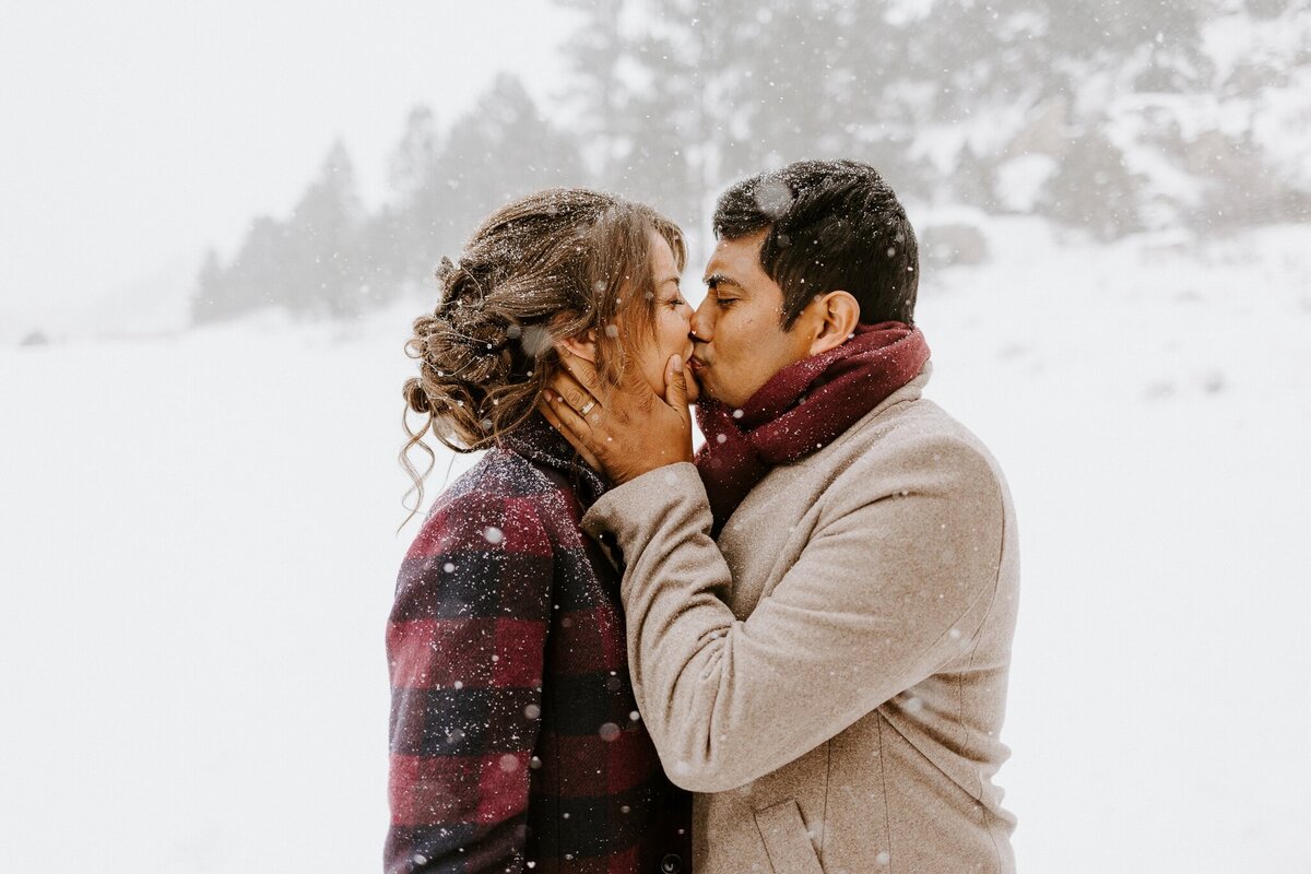 Couple kisses in a winter scene.