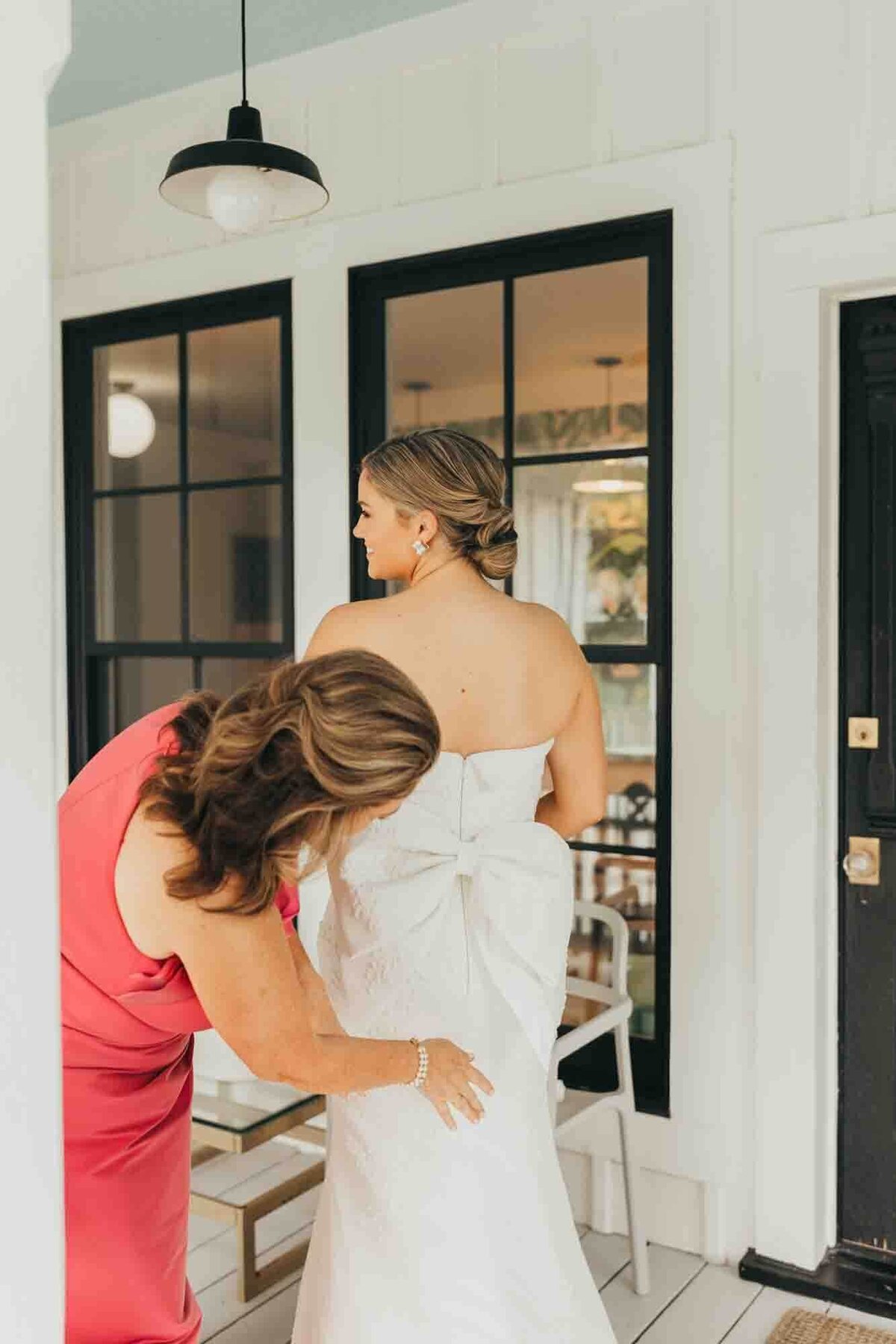 mother zips up her daughters wedding dress moments before she walks down the aisle.