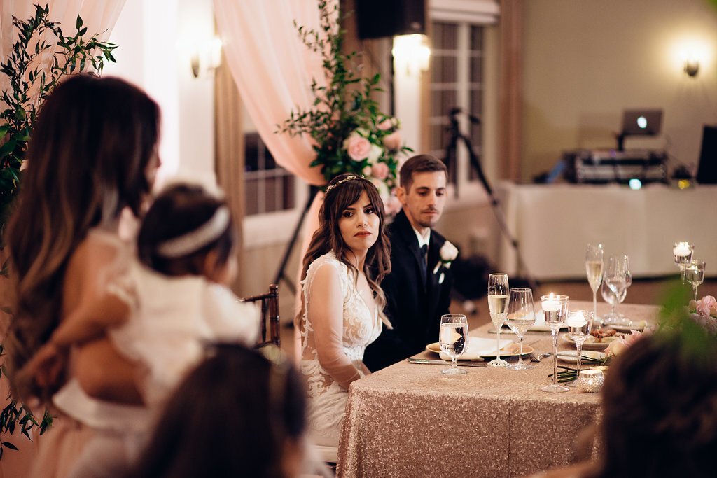 Wedding Photograph Of Bride And Groom Looking At The Woman Speaking in Microphone Los Angeles
