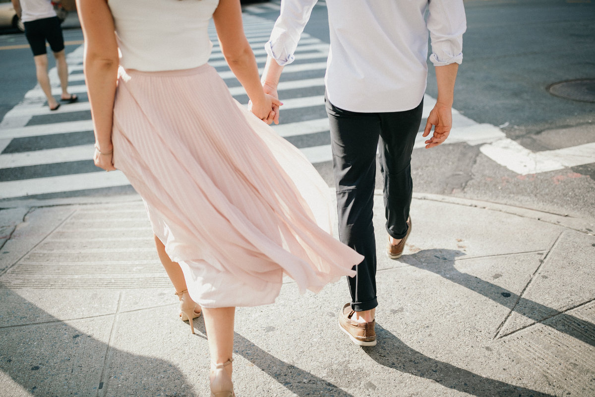 Engaged couple walk hand in hand, photographed by Sweetwater.