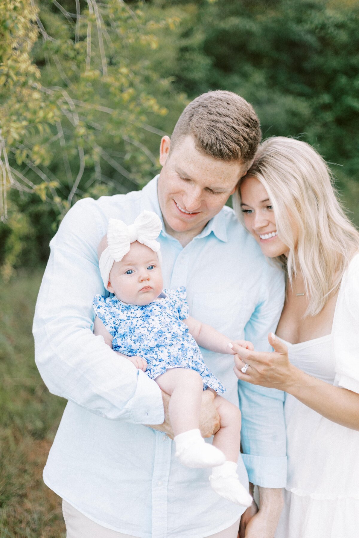 mom and dady smiling at baby during peoria, illinois family photos 