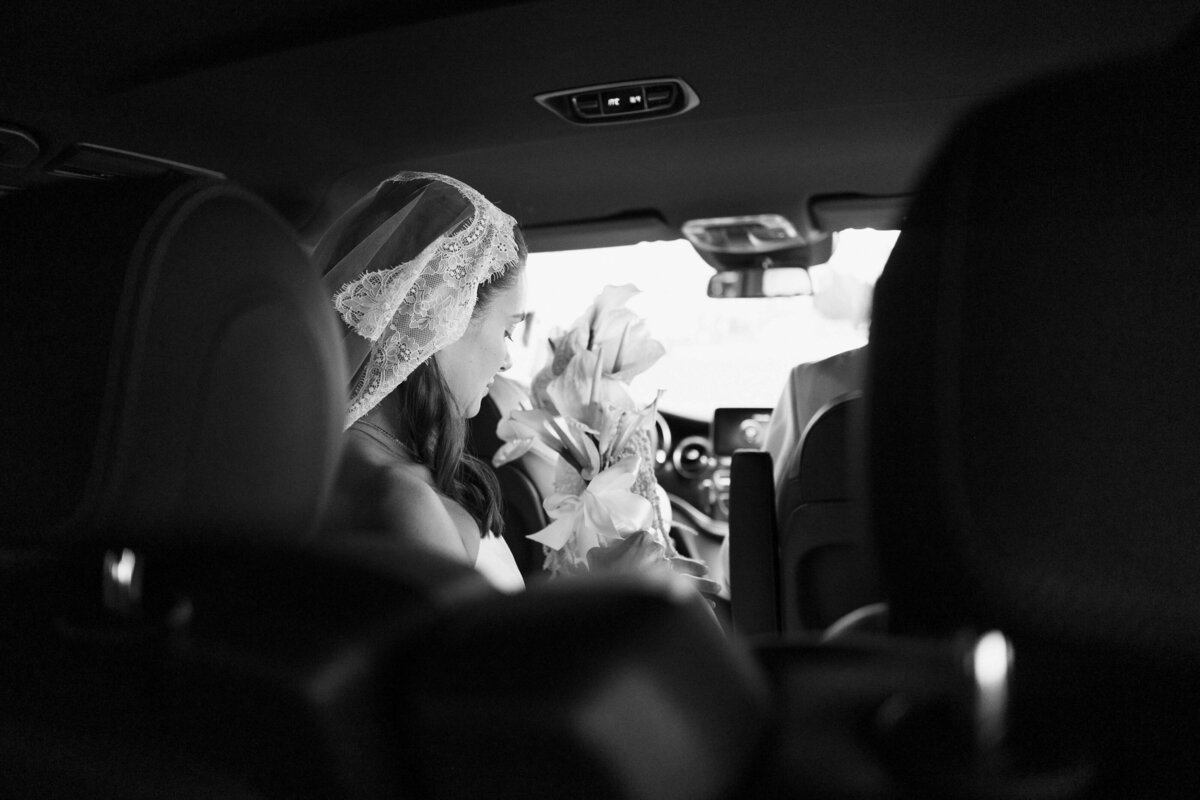 View of bride’s veil and bouquet inside wedding car in Rome

