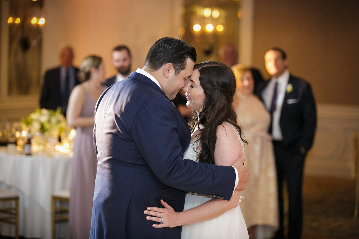 A newlywed couple standing forehead to forehead