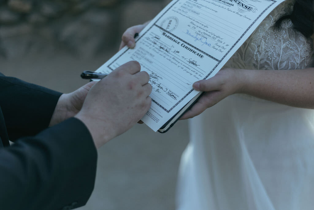 A person signing a marriage certificate.