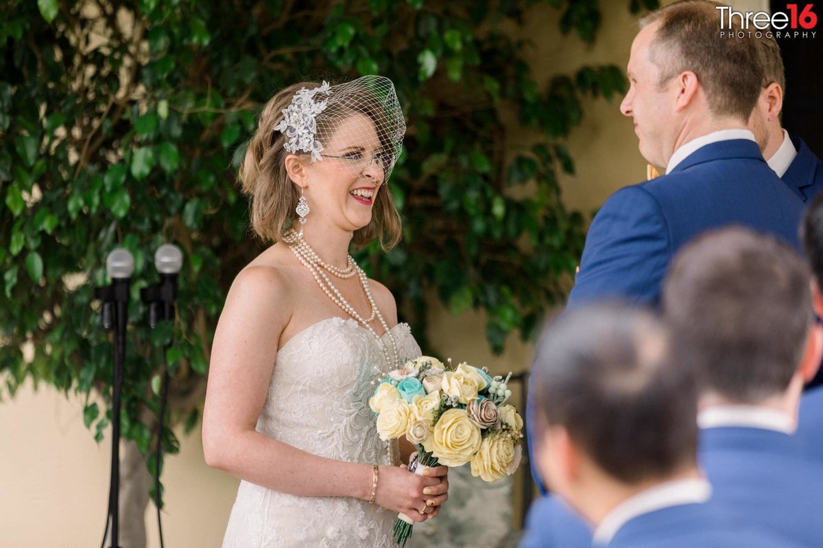 Big smile on the Bride's face as she looks at her Groom during wedding ceremony