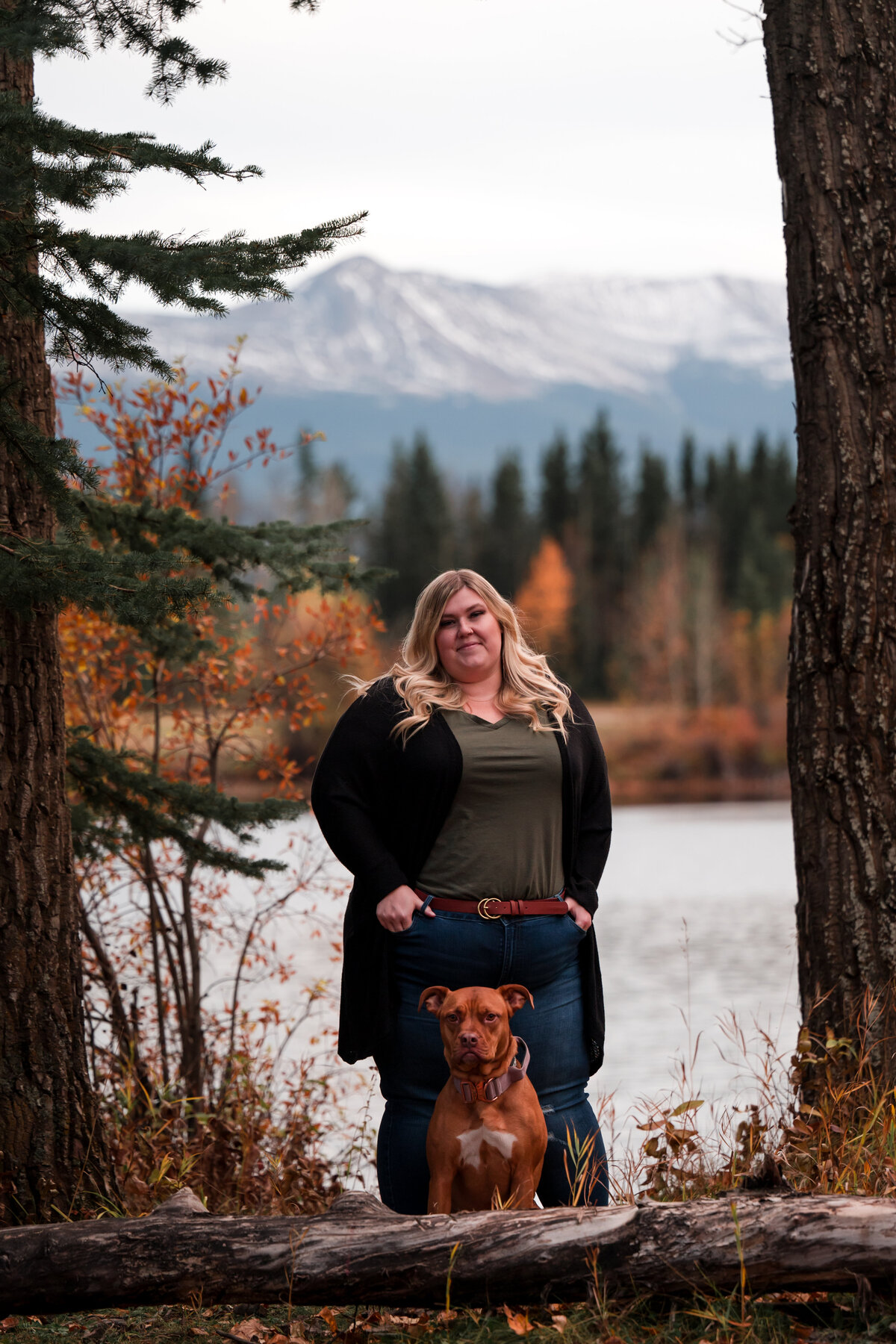 woman and dog pose for photo in the mountains