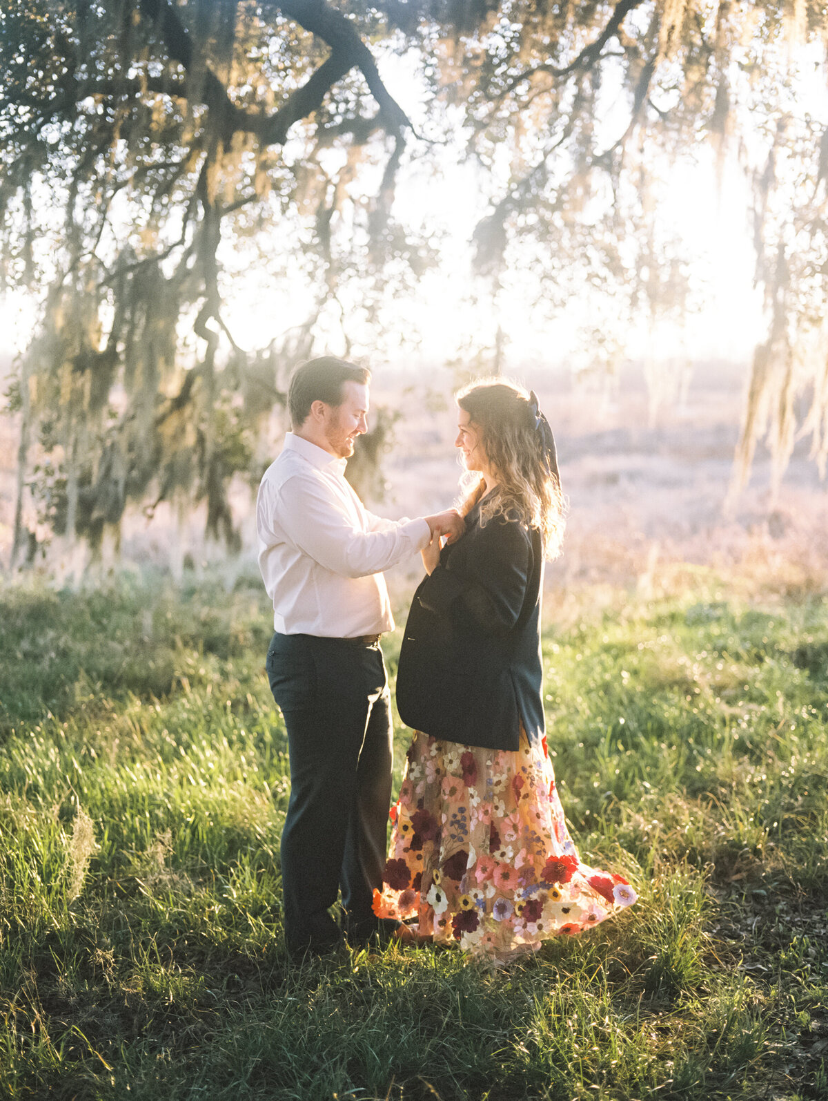 Engaged couple dancing at sunset in colorful attire