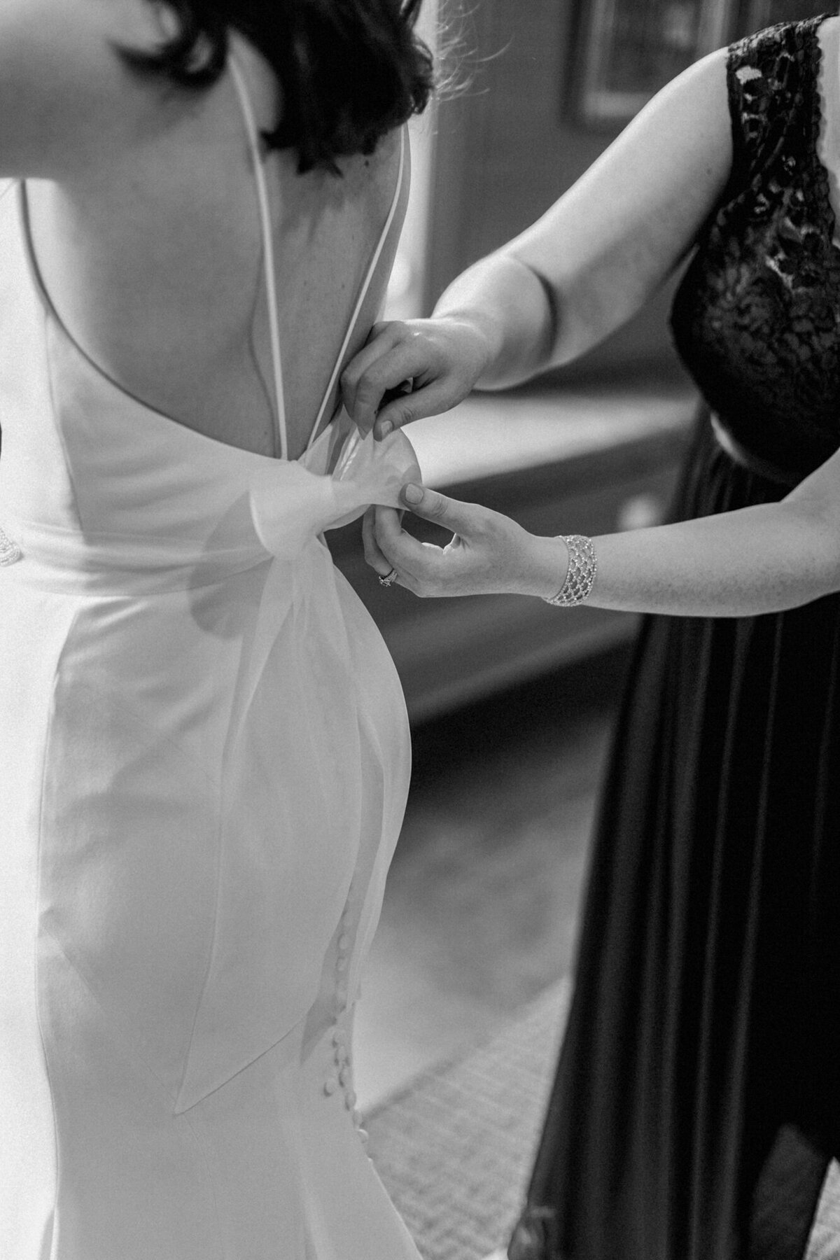 A detail shot of a bow on the back of a bride's wedding dress