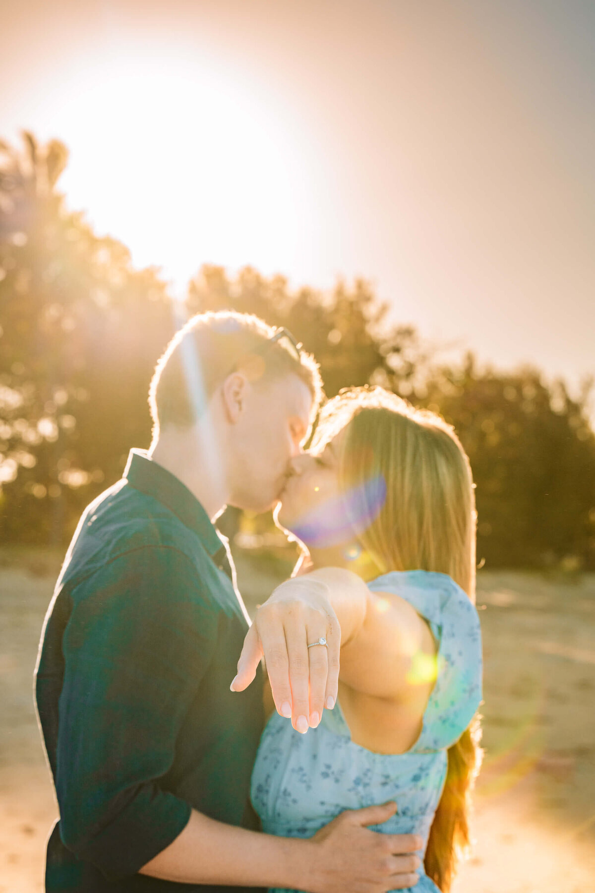 A couple joyfully poses together on the beach, capturing their love in a beautiful engagement photo session. - photo by Jamie Simmons