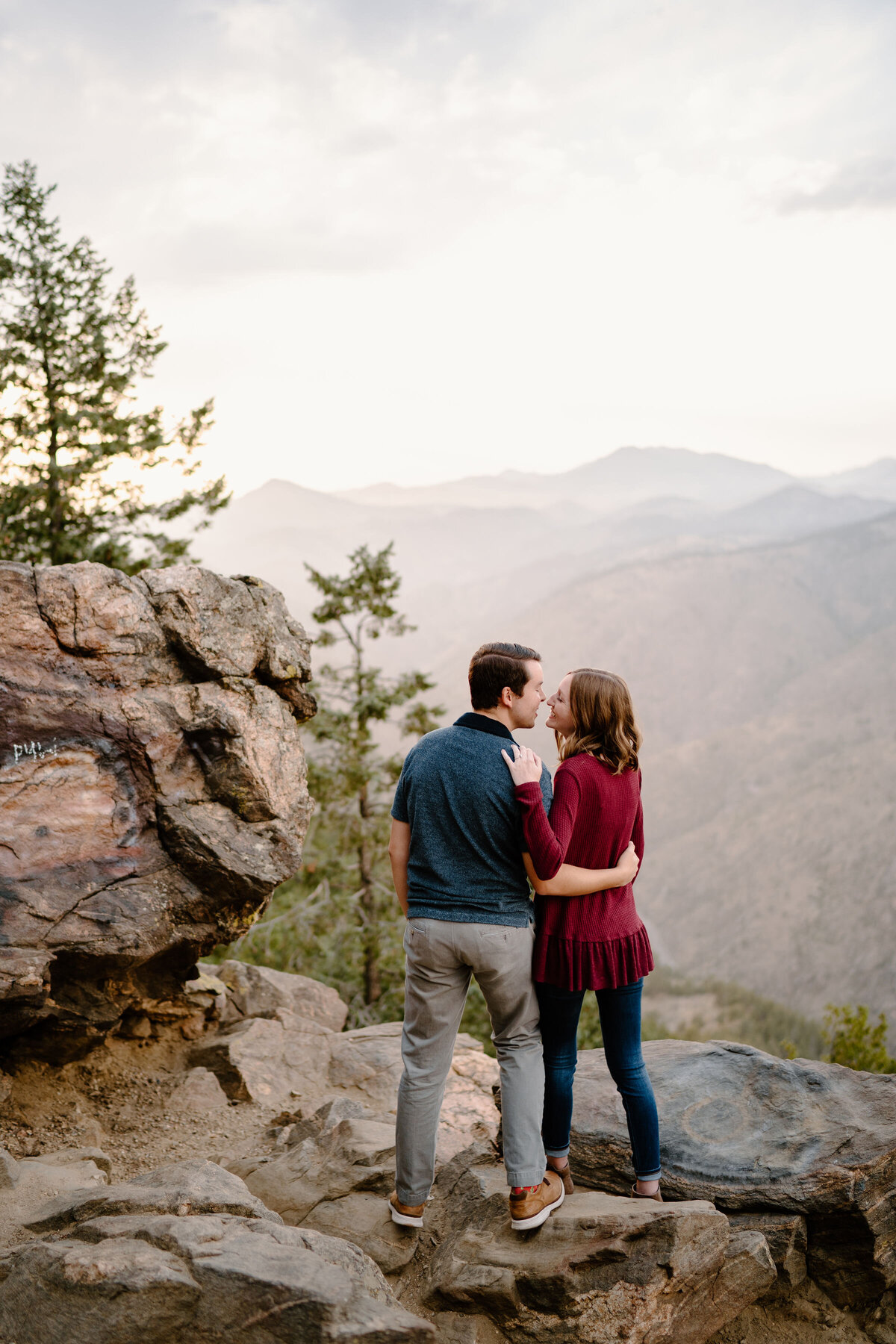 Couple facing away from camera overlooking mountains