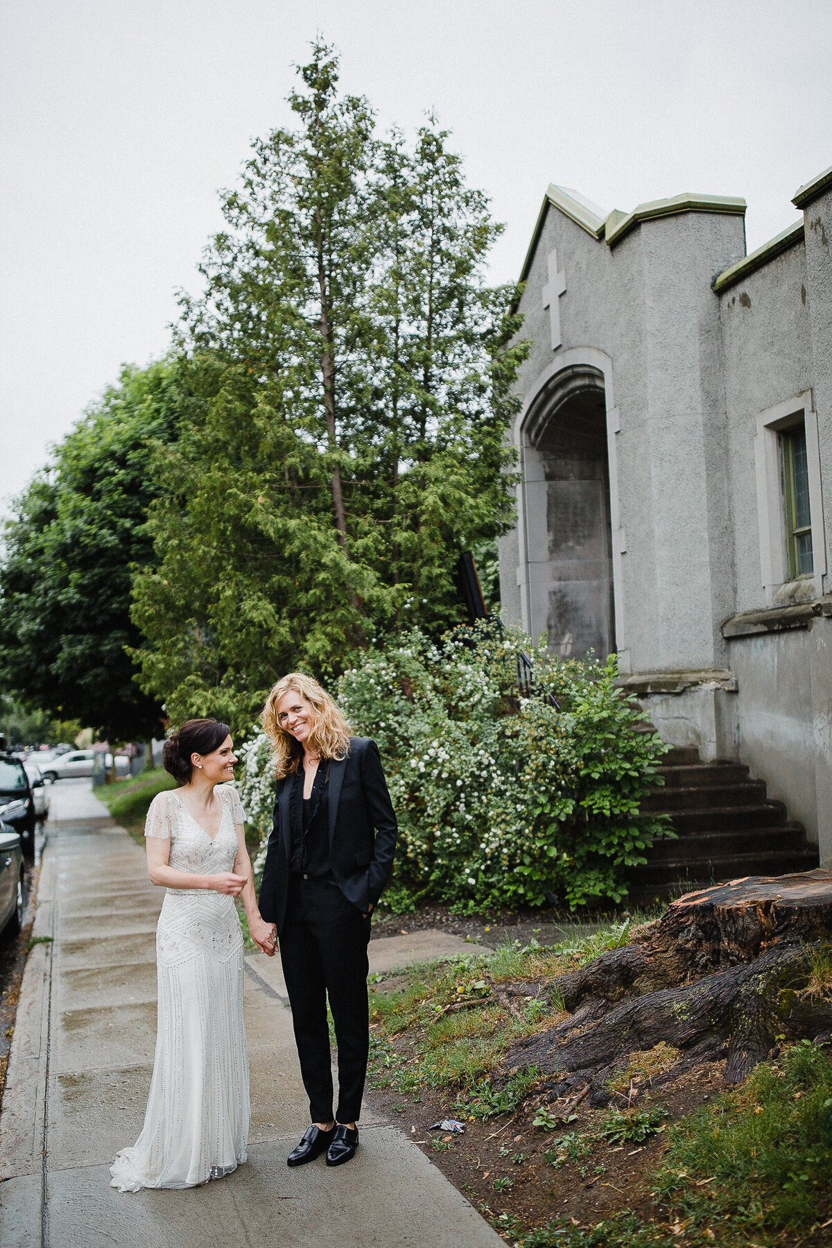 Couple de deux filles se tiennent la main lors de leur mariage pluvieux dans une rue de Montréal dans Outremont. 