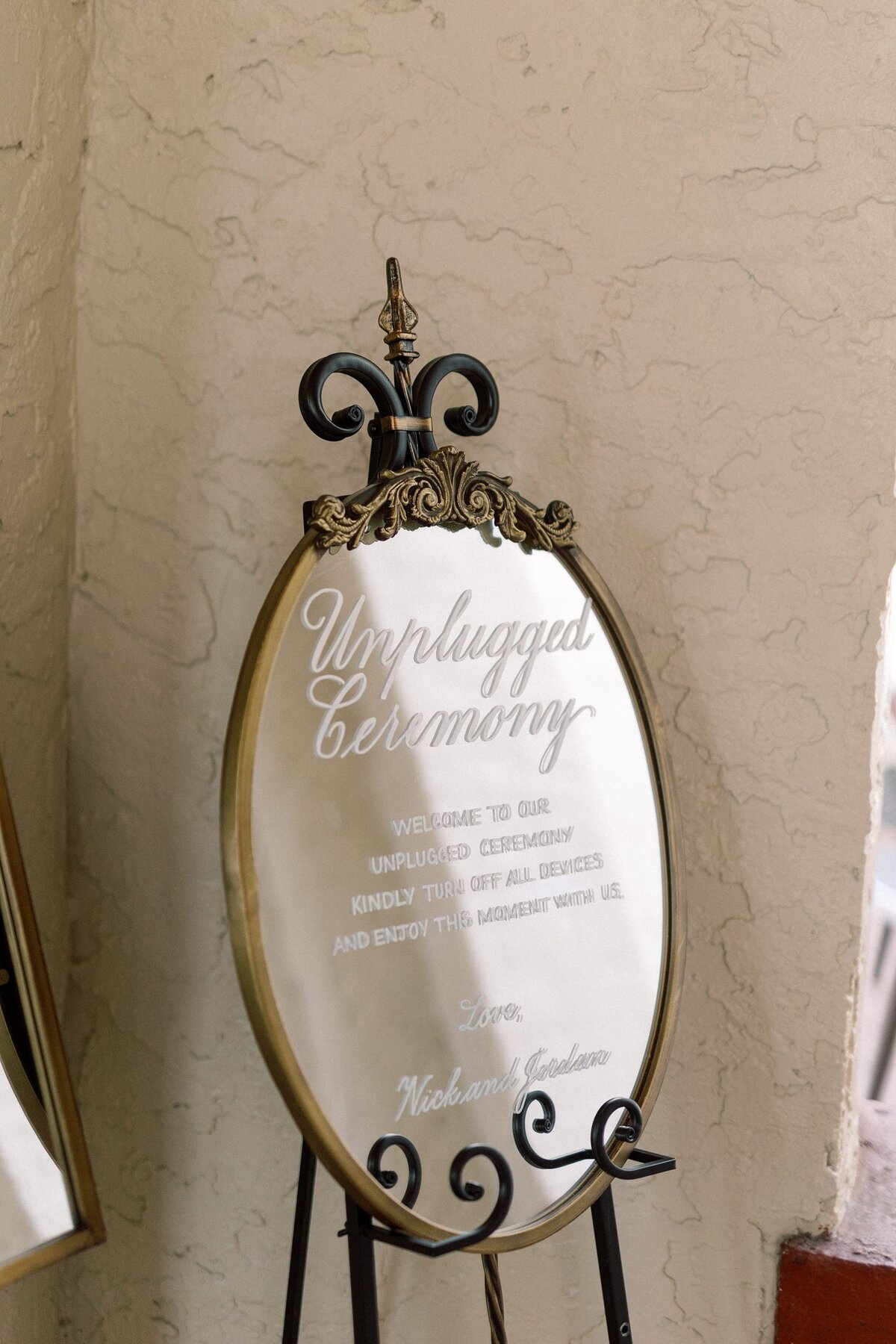 Medium oval mirror with ornate ornament on top and calligraphy for an unplugged ceremony