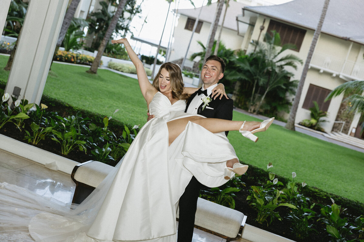 Luxury wedding couple at five-star Hawaiian resort, bride in strapless satin gown and long veil